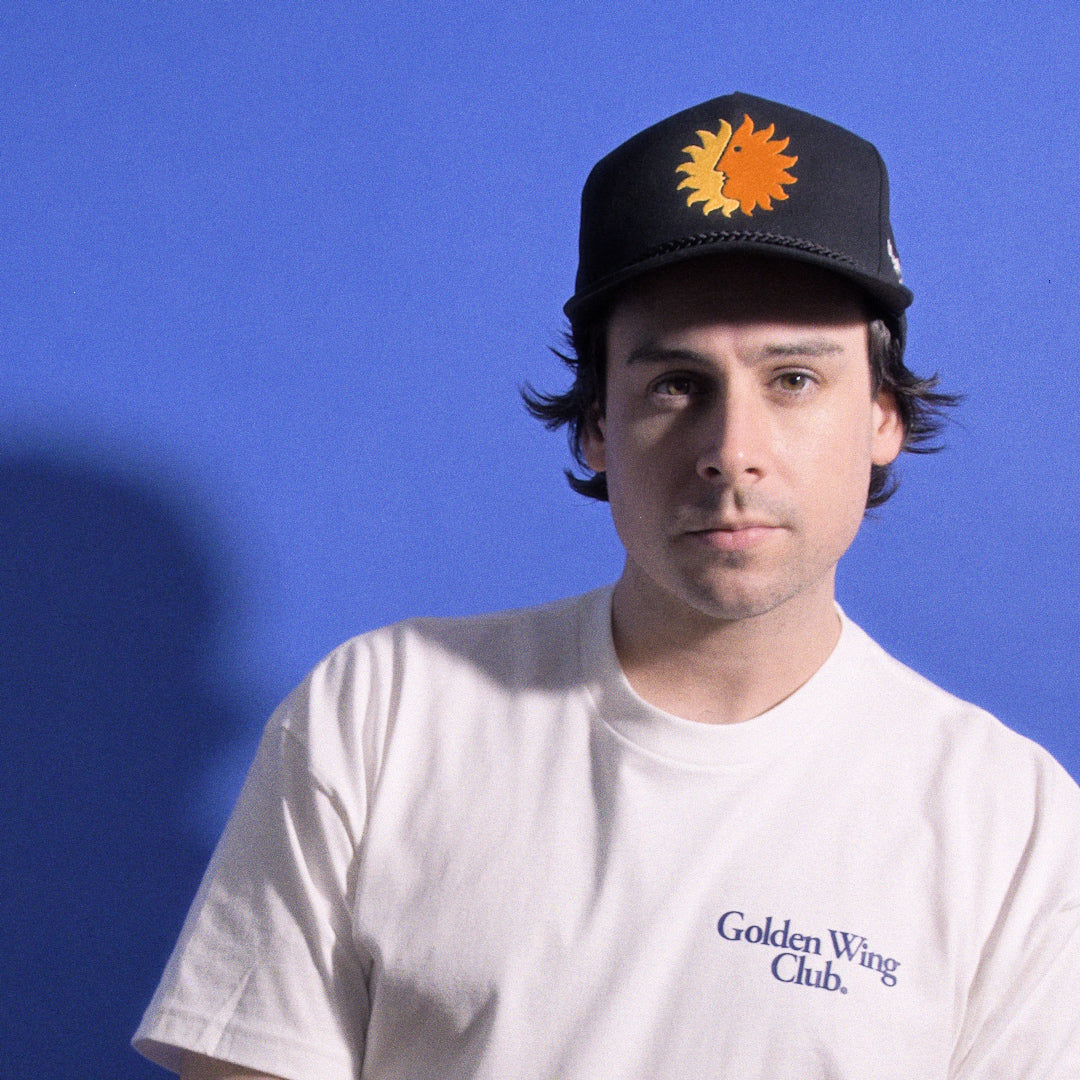 Man wearing national Airlines Sun King Cap from Golden Wing Club looking at camera